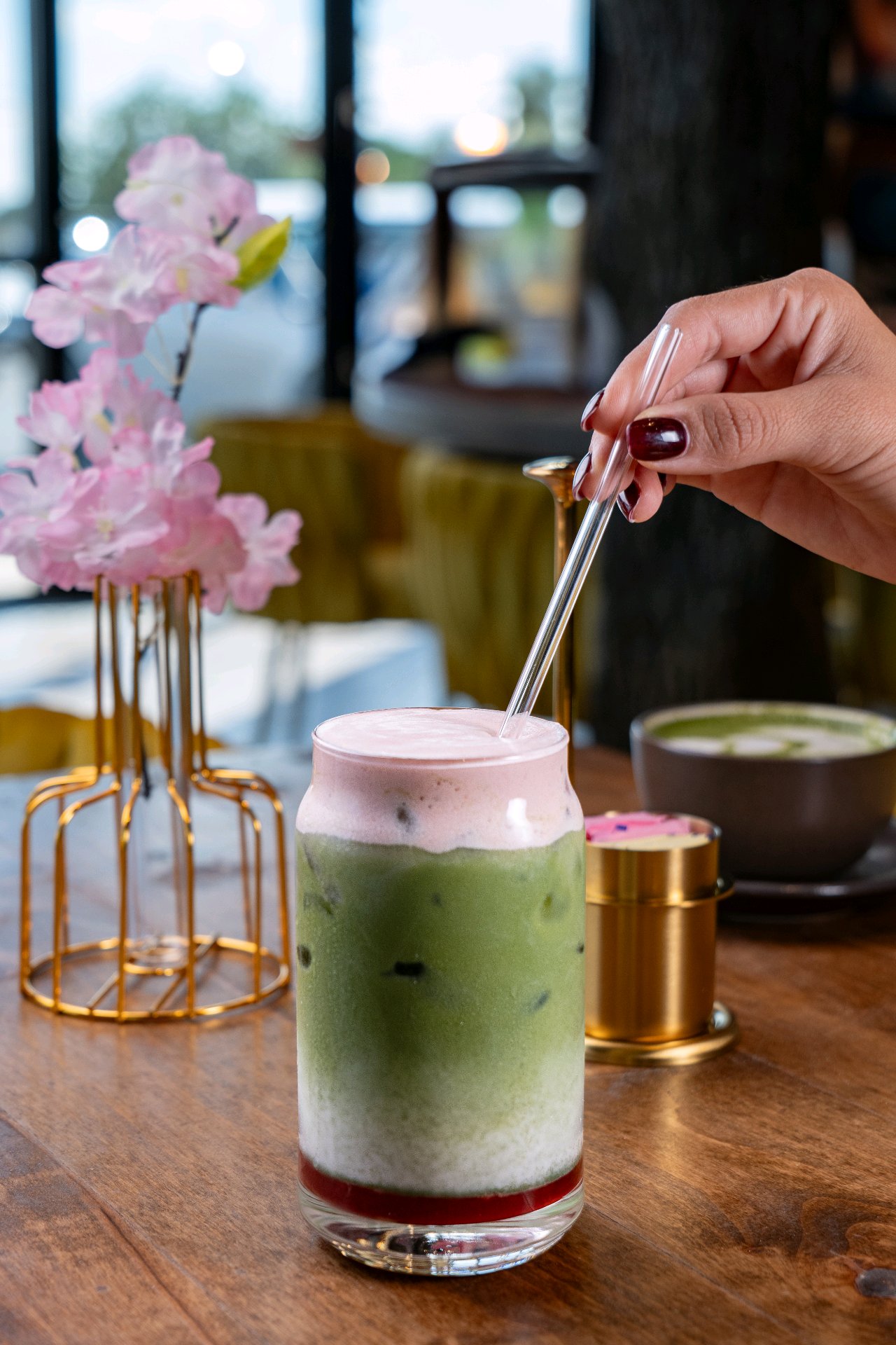 A strawberry matcha being finished at the bar